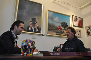 Galeriehouder Arian van der Hoeven van Très Art in gesprek met kunstenaar Roeland van der Kley met op de achtergrond de eerste twee schilderijen van de serie Par-Ys.